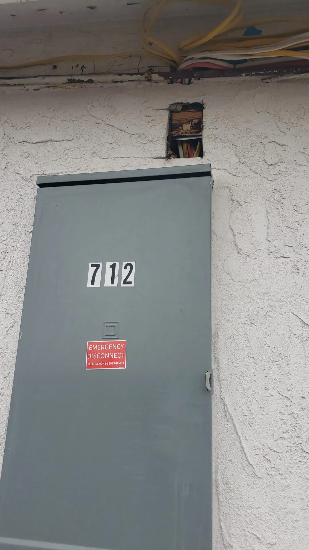 Gray emergency disconnect on exterior stucco. Martinez Electric Corp