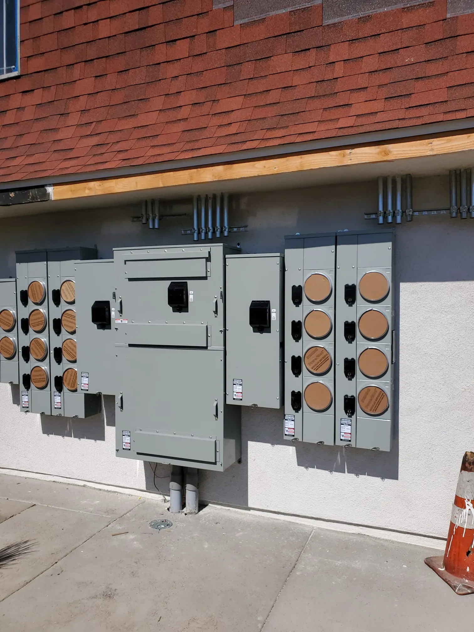 Multi-meter bank installed on exterior stucco wall. Martinez Electric Corp