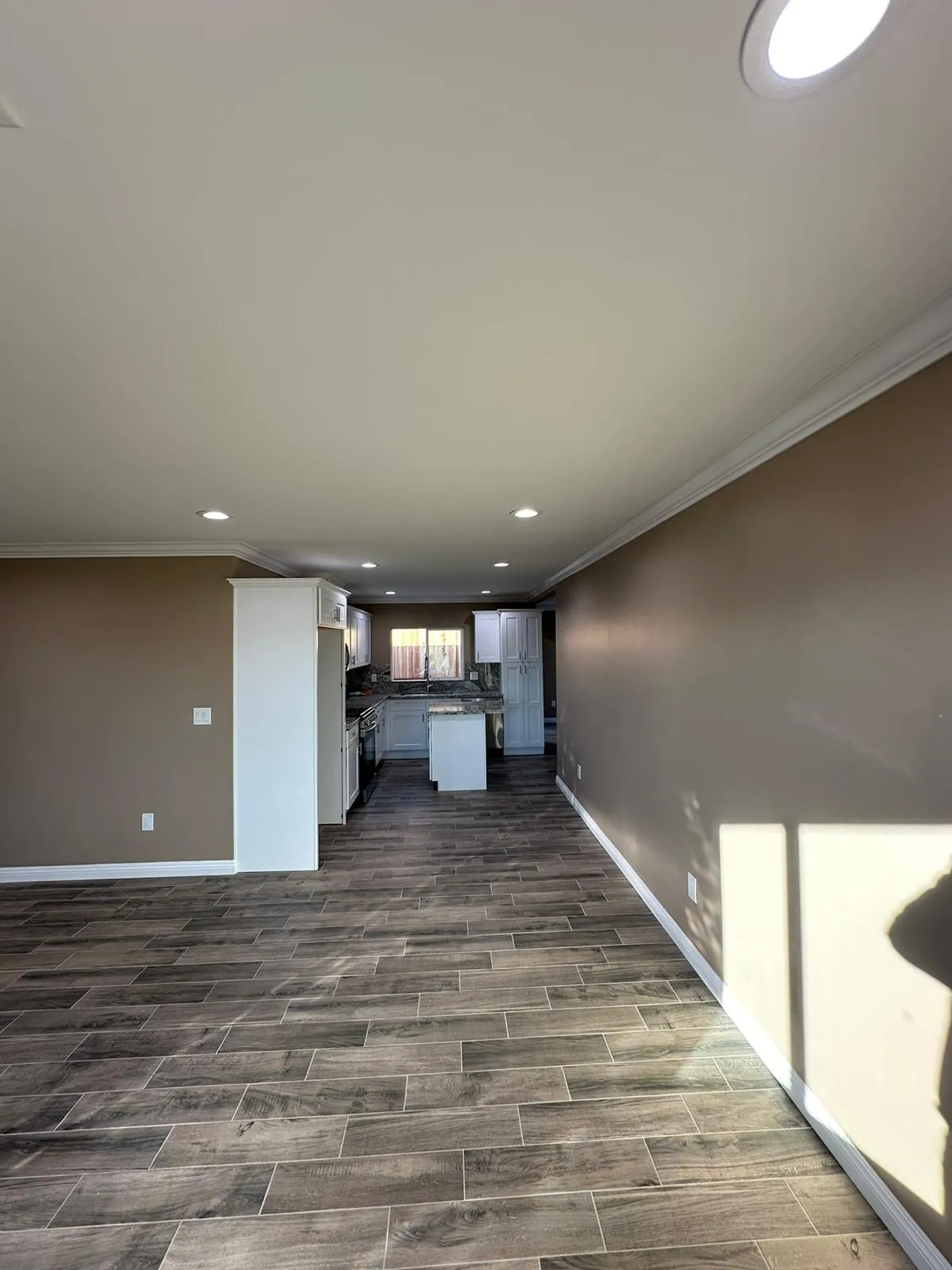 Open floor plan with recessed lighting, brown walls and view to kitchen. Martinez Electric Corp