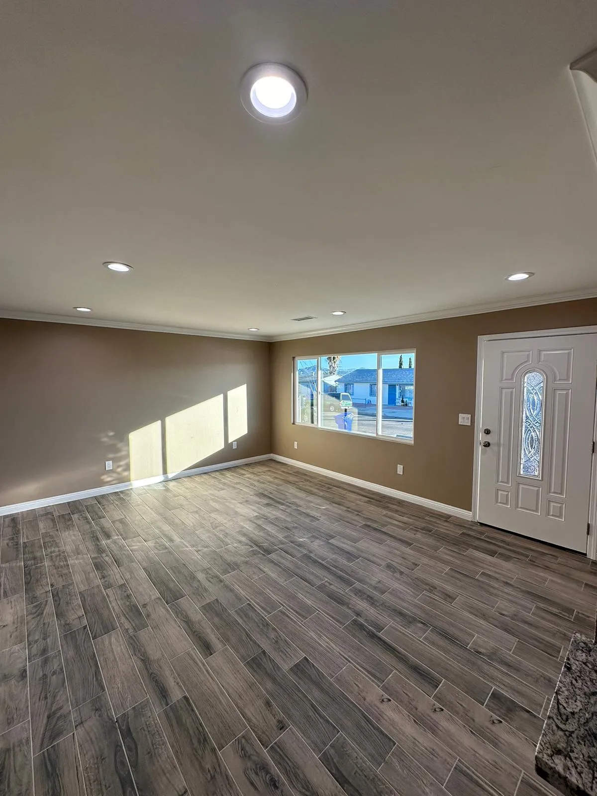 Empty living room with recessed lighting and decorative front door. Martinez Electric Corp