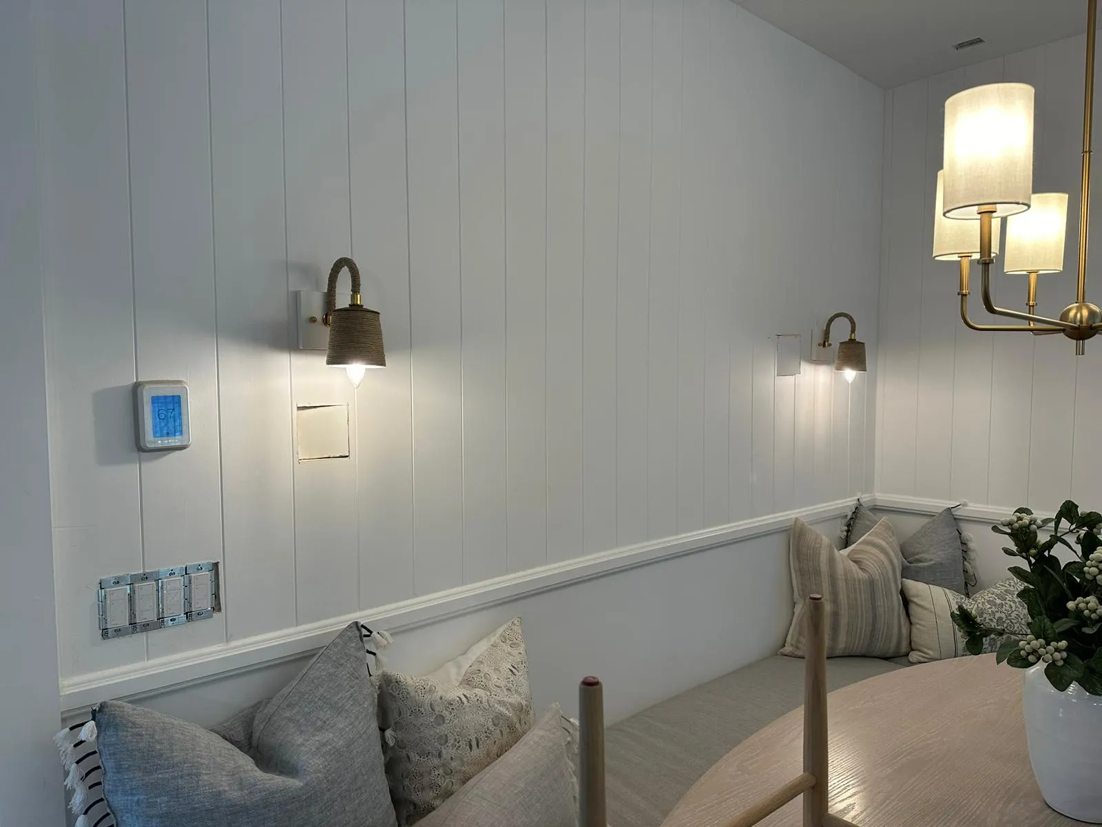 Banquette with rope sconces, brass chandelier and integrated smart switches. Martinez Electric Corp