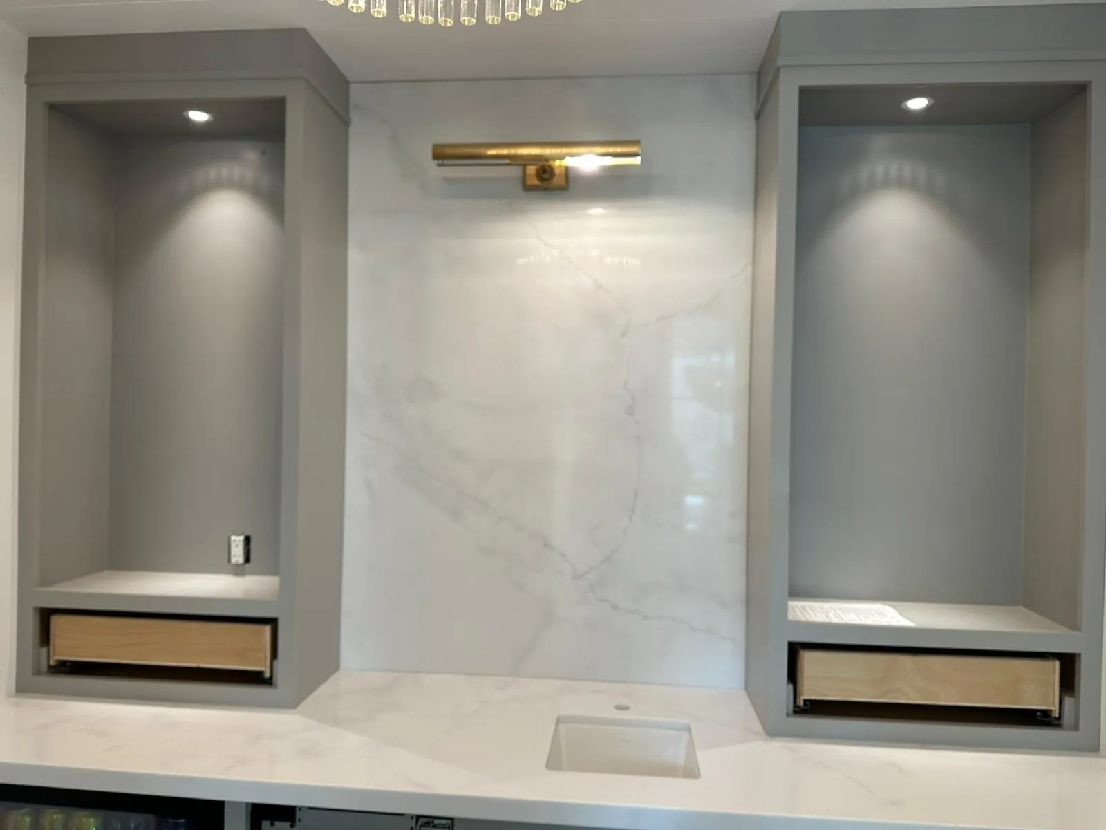 Wet bar with marble back, brass picture light and recessed lighting. Martinez Electric Corp