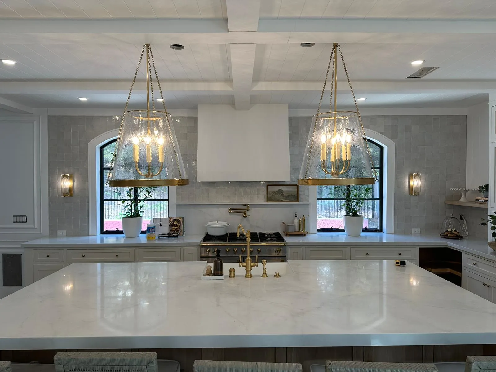 Spanish-style kitchen with twin brass pendant chandeliers, marble island and coffered ceiling. Lighting installed by Martinez Electric Corp
